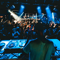 A DJ playing music for a crowd of people.